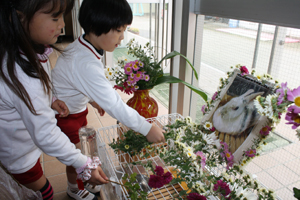 ミミちゃんの遺影にキクの花を供える園児たち　