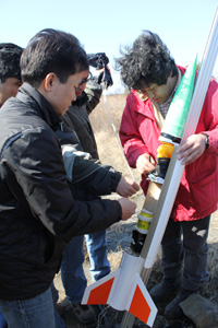 缶サットの打ち上げ準備をする秋山教授と研究者たち