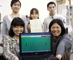 サッカーシュミレーションを手に上山さん㊨と鈴木さん㊧と研究室の皆さん - 近大の学生２人がロボカップで３位入賞