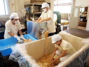 ミンサーで大豆と米をつぶしておけに入れる作業員ら - お盆前にみその製造ピーク　紀美野町