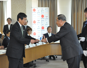 仁坂知事㊧に開催決定書が手渡された（11日、東京で）
