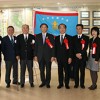 大会旗を囲む関係者（中央の仁坂知事から左に山本理事長、仙石大会実行委員長）