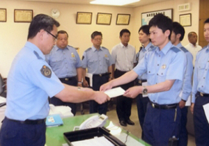 鳴海署長㊧から指定書の交付を受ける若手警察官