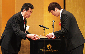 式典で前田会長㊧から代表者に表彰状が贈られた