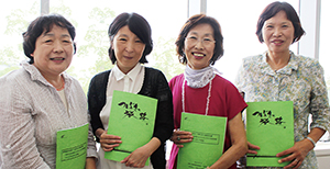 記念誌を手に、塩谷さん、西本副会長、岡田会長、大橋さん（左から）