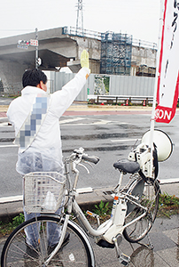 雨の中、自転車で活動する候補者