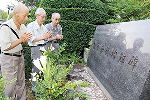 同窓生の慰霊碑の前で手を合わせる（左から）辻田さん、二越さん、井原さん