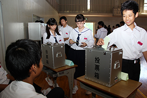 実際の投票箱に１票を投じる生徒たち