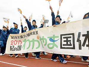 入場行進で笑顔で旗を振る和歌山県選手団