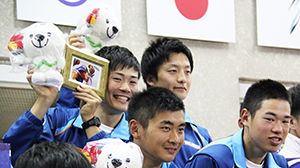 表彰台で和田の写真を掲げる優勝メンバー（後列左から右へ佐々木、窪木、岡本、森口）