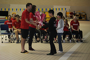 カナダの選手やスタッフに花束を渡す小学生