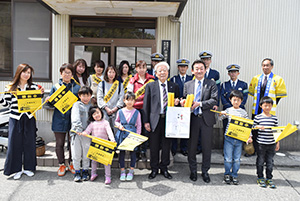 黄旗の袋を手に藤本支店長（前列中央右）と新家支部長（左隣）ら