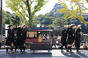 和歌山城前を通る大名行列の駕籠から手を振る中瀬さん
