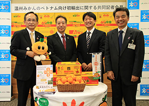 ベトナムへの輸出が始まる「有田みかん」を囲んで笑顔の（左から）楠本理事長、森田組合長、後藤所長、岩本部長