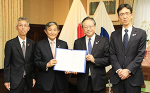 協定書を手に（左から）田谷理事長、仁坂知事、川本理事長、横田常務理事