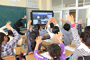 手を振って交流会を楽しむ雑賀崎小学校の児童ら