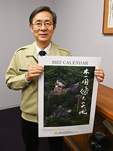 ２０２２年版カレンダー「木の国悠久の大地」を手に竹田専務