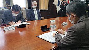 協定書に署名する仁坂知事（手前）と平石会長