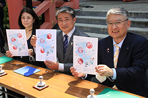 スタンプを押した台紙を手に（左から）森議長、薛総領事、中会長