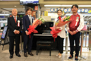 中央改札のピアノの前で（左から）中村会長、藤原課長、山下さん、岩端会長