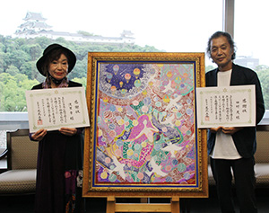 絵画「希望」と寄贈した田村さん㊨と渡里さん