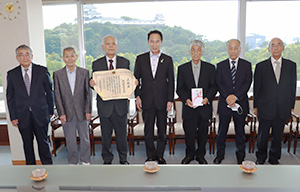 表彰状を手にする川口会長（左から３人目）と尾花市長（中央）、副会長の皆さん（和歌山市提供）