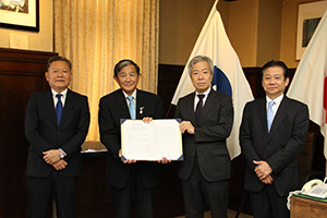 協定書を手にする仁坂知事（左から２人目）、貞広副社長（同３人目）ら