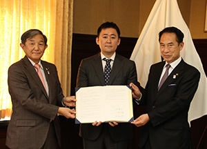 協定書を手に（左から）仁坂知事、石井社長、尾花市長