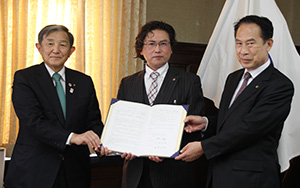 協定書を手にする（左から）仁坂知事、伊賀上代表取締役、尾花市長