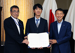 協定書を手に（左から）佐藤副市長、陳副社長、岸本知事