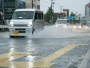 水しぶきを上げ冠水した道路を走る自動車（和歌山市吹屋町）