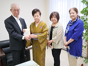 石田代表（左から２人目）が中芝市長に募金を手渡した