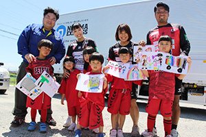 野嶋社長㊧と、描いた絵を手に参加した子どもたち