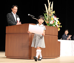 尾花市長㊧から表彰状を受け取った代表児童