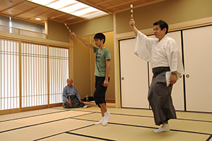 小林さん（左後方）、橋本さん㊨に教わりながら扇子を手に舞う参加者