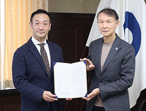 協定書を手に（左から）佐藤副理事長、岸本知事