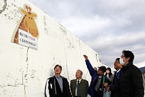津波の高さを示す看板の前で、東北や和歌山のメンバー